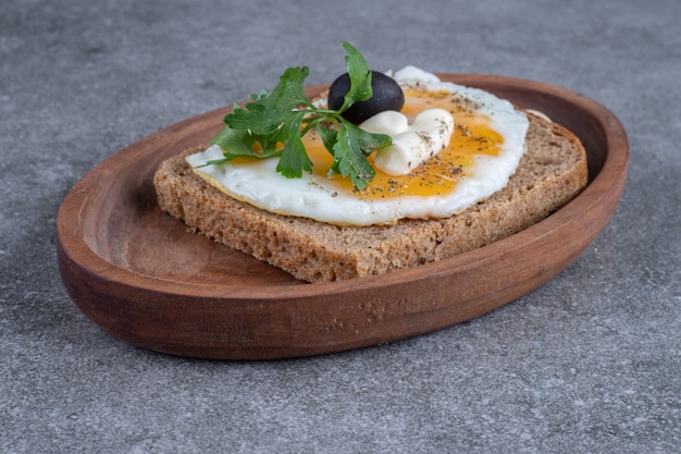 Una tabla de madera de deliciosas tostadas con huevo cocido. Foto de alta calidad