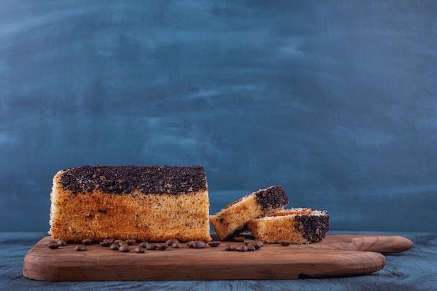 Tabla de madera de delicioso bizcocho sobre fondo de mármol.