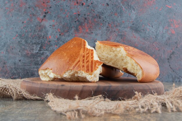 Una tabla de madera de deliciosos pasteles dulces sobre una tela de saco