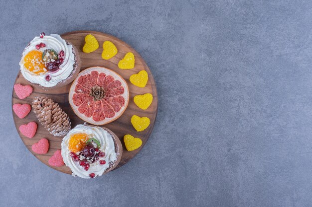 Una tabla de madera con dulces y galletas de gelatina azucarada