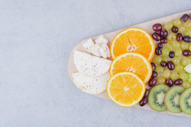 Una tabla de madera de frutas frescas sobre fondo blanco. Foto de alta calidad