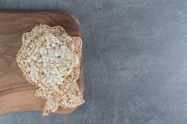 Una tabla de madera de gofres de arroz cuadrados crujientes.