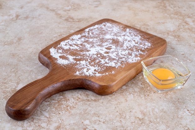 Foto gratuita una tabla de madera de harina y yema cruda.