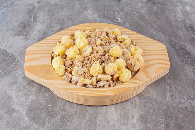 Una tabla de madera llena de deliciosos cereales saludables para el desayuno.