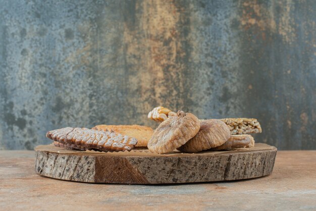 Una tabla de madera llena de galletas dulces y bollos de maní.