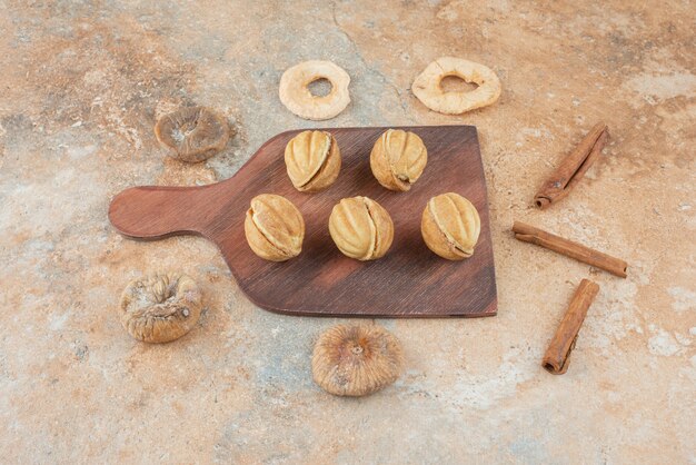 Una tabla de madera llena de galletas dulces y ramitas de canela.