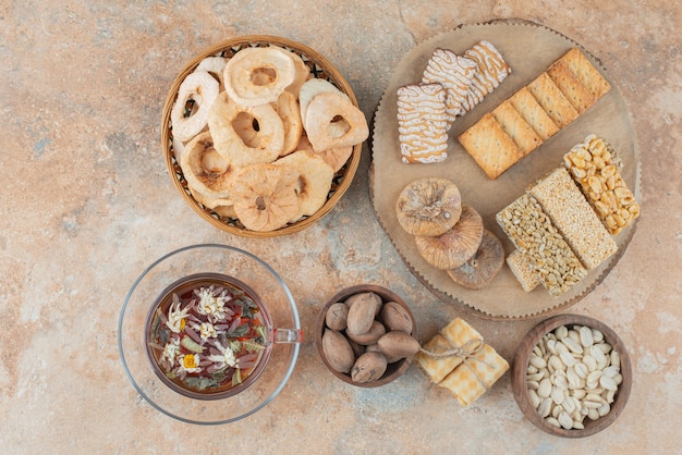 Una tabla de madera llena de galletas dulces y una taza de té de hierbas.