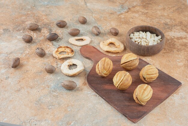 Una tabla de madera llena de galletas dulces y una taza de té de hierbas.