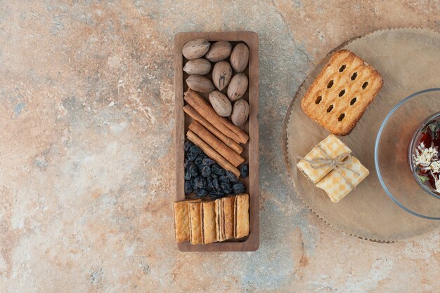 Una tabla de madera llena de galletas dulces y una taza de té de hierbas.