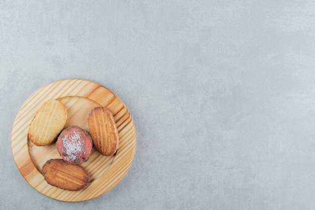 Una tabla de madera llena de galletas dulces.