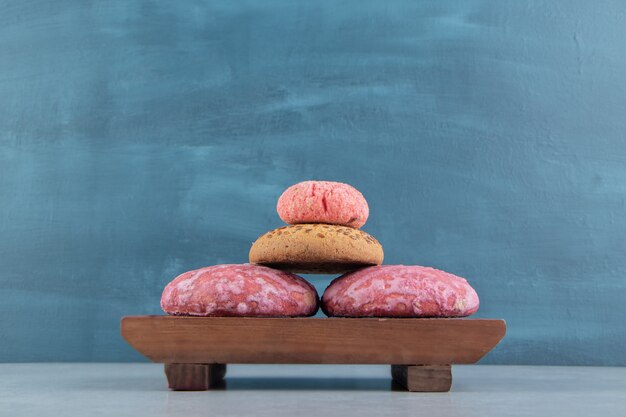 Una tabla de madera llena de galletas dulces.