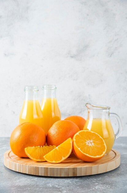 Una tabla de madera llena de jugosas rodajas de fruta naranja en la mesa de piedra.