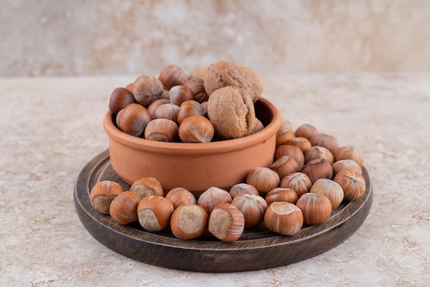 Una tabla de madera llena de nueces de macadamia saludables.