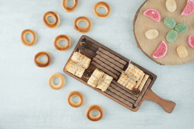 Una tabla de madera llena de pasteles y mermelada sobre fondo blanco. Foto de alta calidad