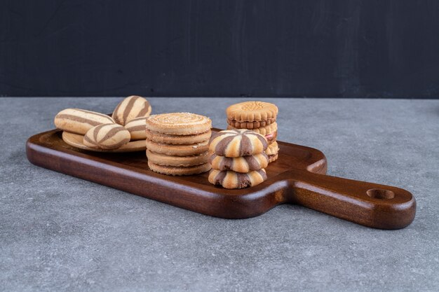 Una tabla de madera con una variedad de galletas agrupadas.