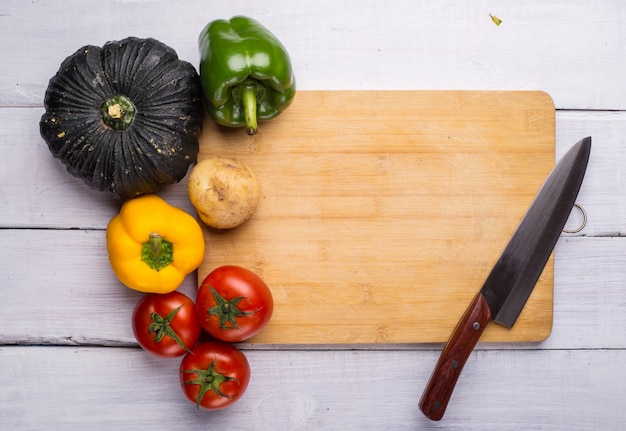 Tabla de picar con verduras y un cuchillo