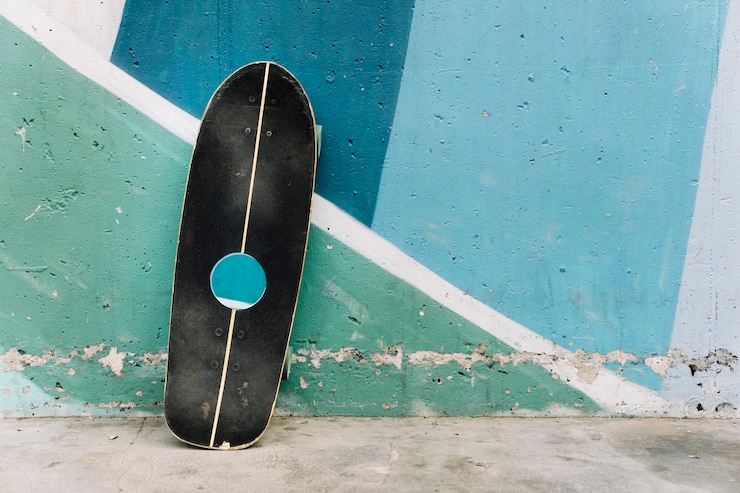 Foto gratuito tabla de skate apoyada contra pared