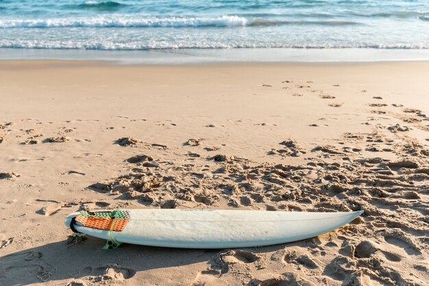 Tabla de surf blanca tumbado en la arena