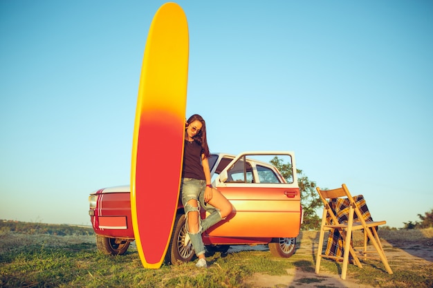 La tabla de surf, coche, mujer.