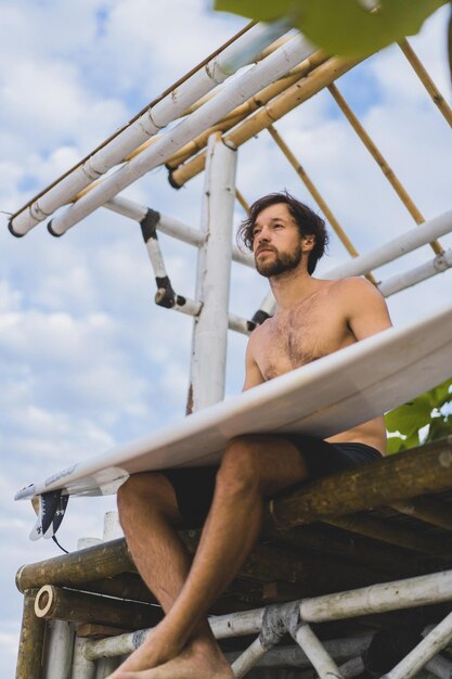 Tabla de surf Surfer Deporte al aire libre Tropical Ocean Concept. Hombre guapo joven con una tabla de surf en el océano.