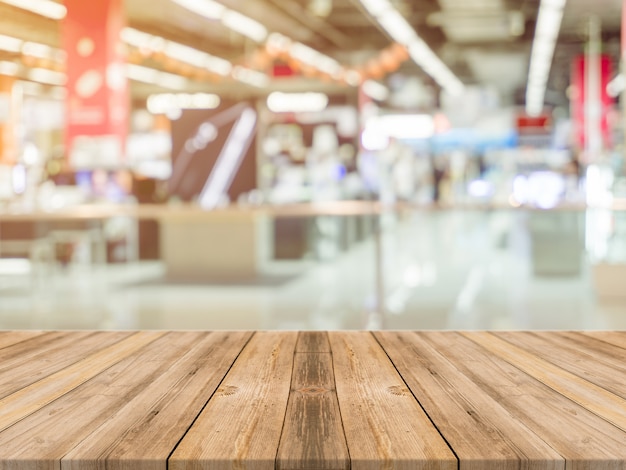 La tabla vacía del tablero de madera empañó el fondo. Perspectiva de madera marrón sobre desenfoque en grandes almacenes: se puede utilizar para exhibir o montar sus productos. Prepárese para ver el producto.