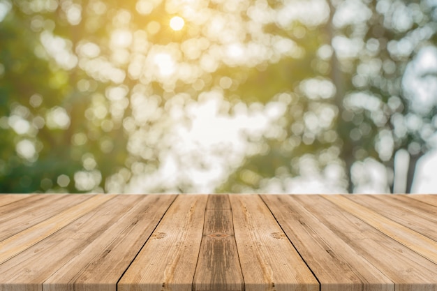 Tablas de madera con árboles desenfocados de fondo