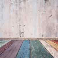 Foto gratuita tablas de madera de colores estropeadas y una pared estropeada de cemento