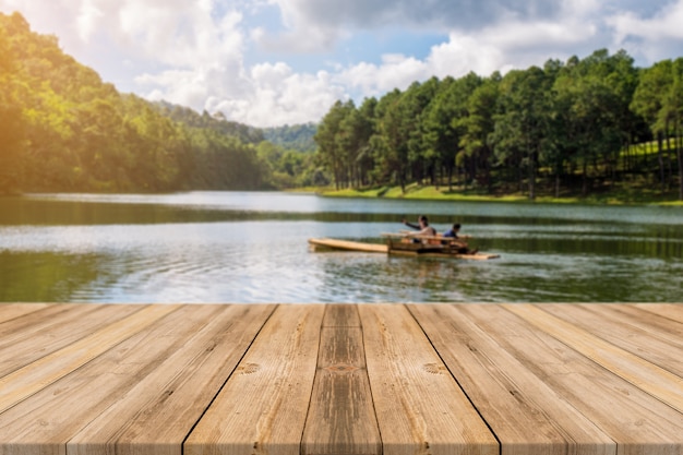 Tablas de madera con un lago con una barca
