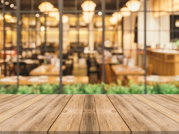 Tablas de madera con restaurante borroso de fondo