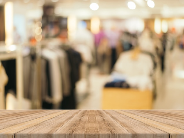 Tablas de madera con tienda de ropa borrosa de fondo