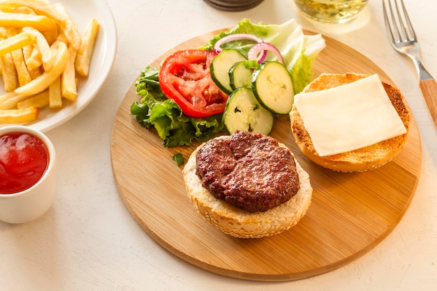 Tablero de madera con hamburguesas y papas fritas