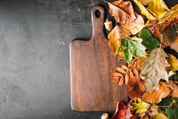 Foto gratuita tablero de madera en hojas de otoño