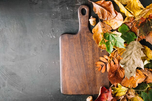 Tablero de madera en hojas de otoño