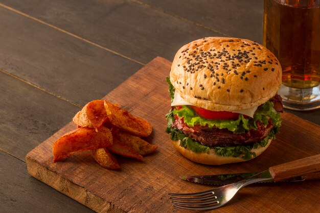 Tablero de madera con papas fritas y hamburguesa