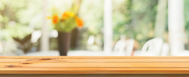Tablero de madera vacío superior de la mesa de fondo borrosa. Perspectiva mesa de madera marrón sobre desenfoque en el fondo cafetería. Bandera panorámica - se puede utilizar simulacro para la presentación de productos de montaje o diseño.