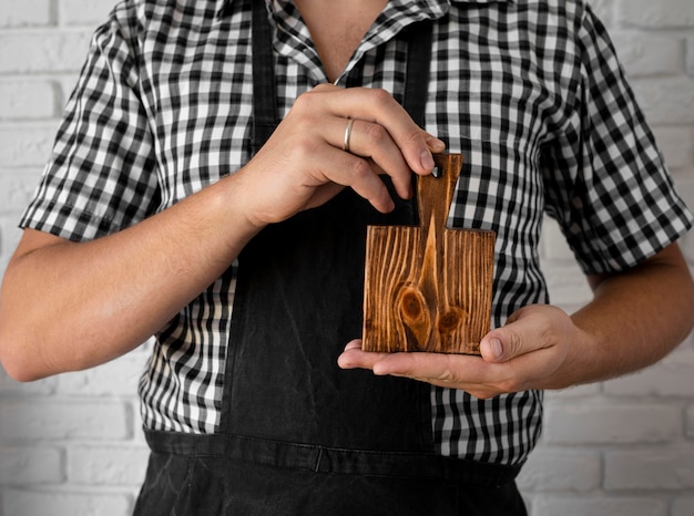 Tablero de madera de vista frontal sostenido por el hombre