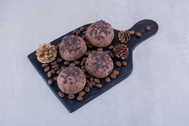 Foto gratuita tablero negro con granos de café, galletas y una piña sobre fondo blanco.