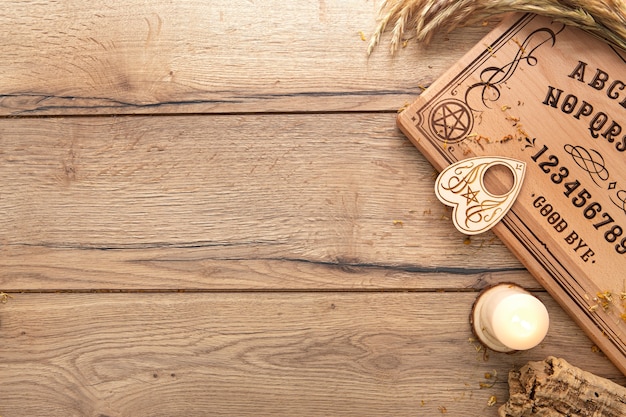 Foto gratuita tablero de ouija y velas con espacio de copia.