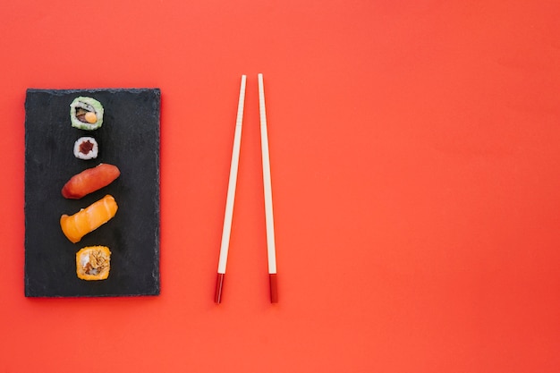 Foto gratuita tablero con rollos y palillos en rojo