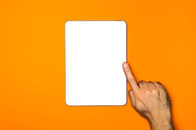 Foto gratuita tablet maqueta vista superior con fondo naranja