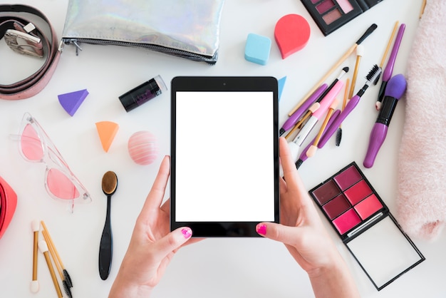 Tablet rodeada de maquillaje