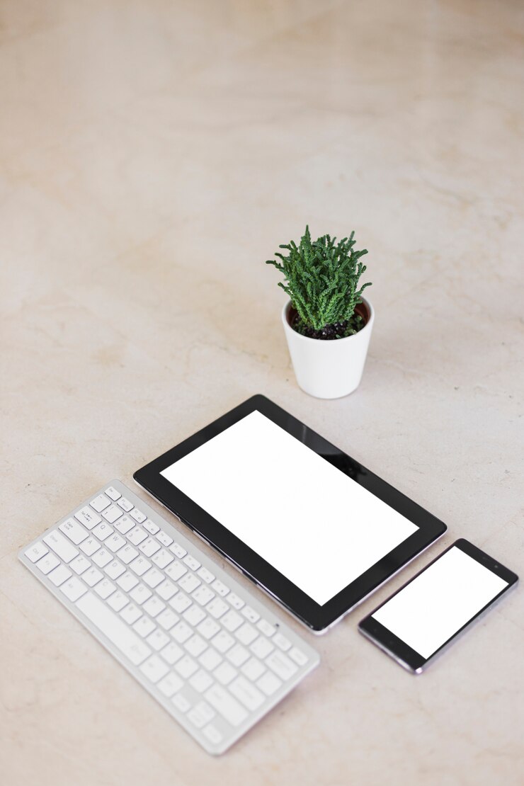 Foto gratuito tablet y smartphone con pantallas en blanco en mesa.
