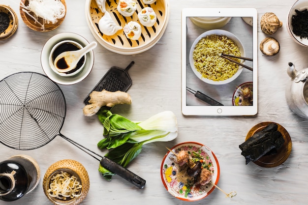 Foto gratuita tableta cerca de platos asiáticos