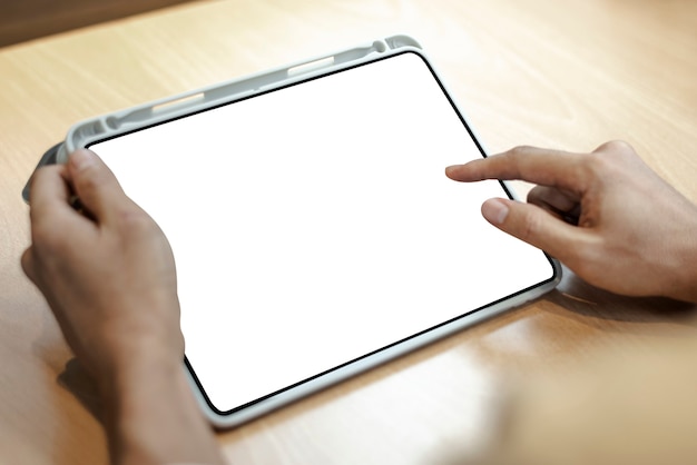 Tableta digital en blanco sobre una mesa de madera clara