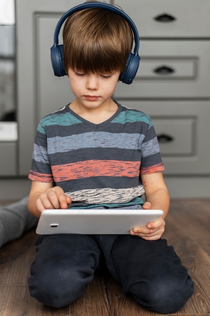 Foto gratuita tableta de explotación de niño de tiro completo