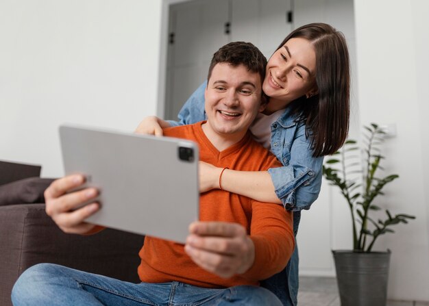 Tableta de explotación de pareja sonriente de tiro medio