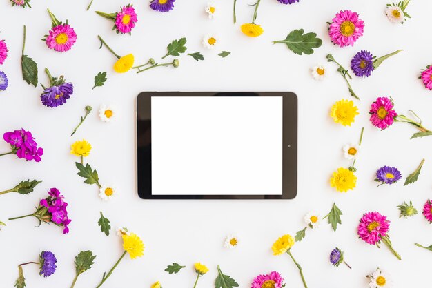 Tableta entre flores de colores