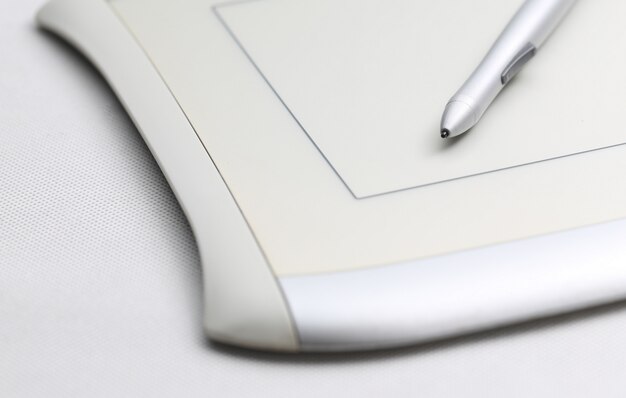 Tableta gráfica y lápiz sensible a la presión sobre fondo blanco