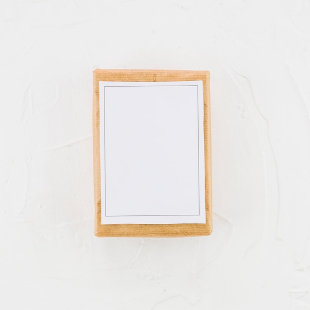 Tableta de madera con papel blanco.