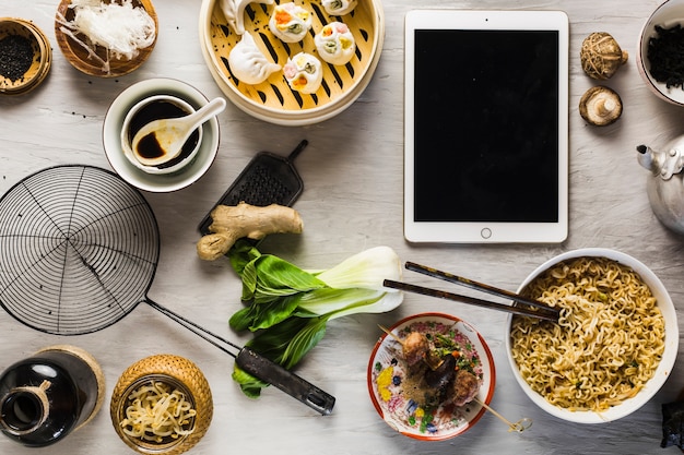 Tableta en medio de la comida asiática